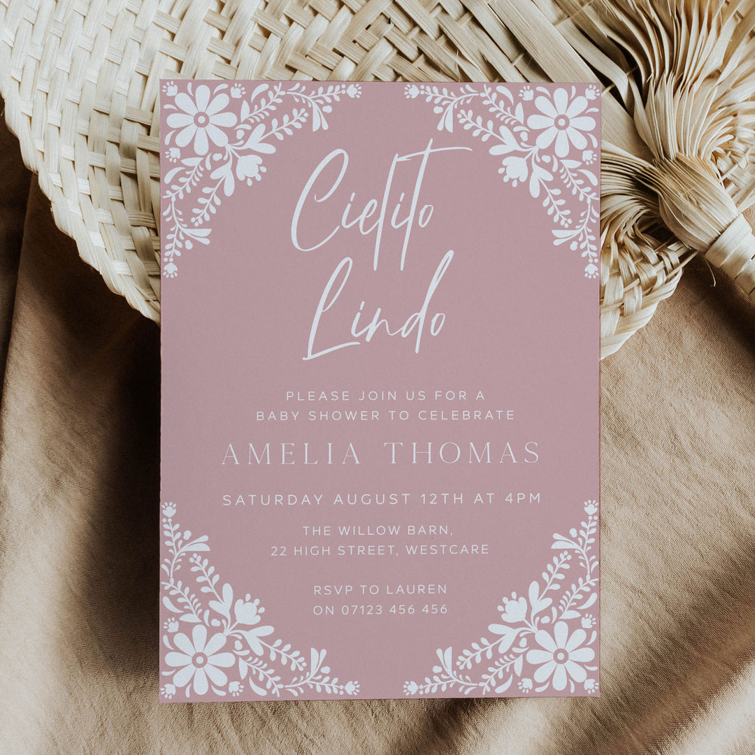 Pink Cielito Lindo baby shower invitation with white floral border, perfect for a feminine fiesta-themed celebration.