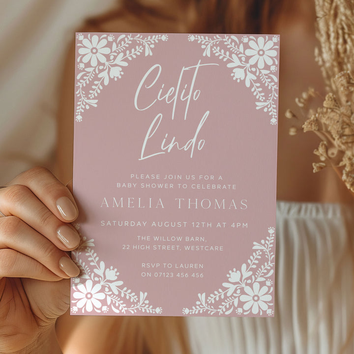 Fiesta baby shower invitation in soft pink tones, styled with rustic natural textures for a charming and cultural celebration.