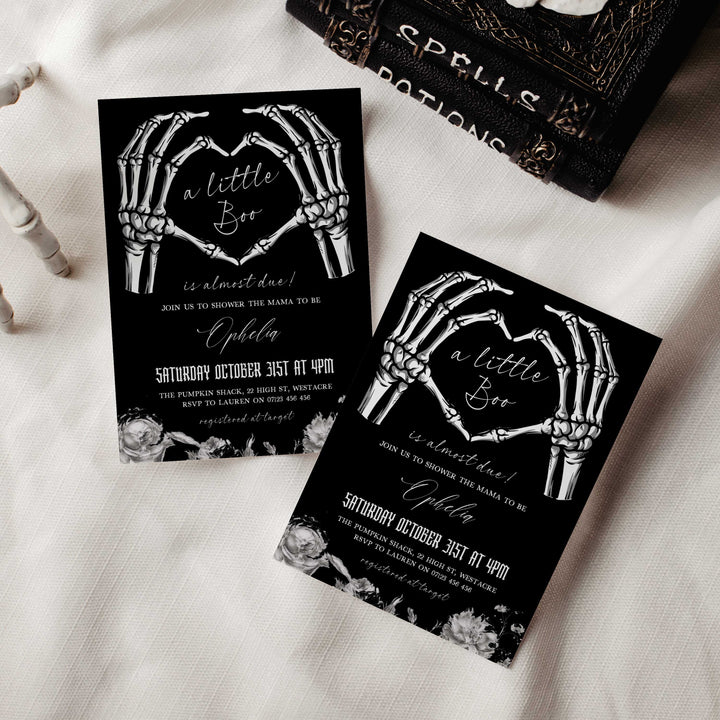 Spooky Halloween baby shower card featuring skeleton hands, gothic fonts, and elegant floral details for mom-to-be