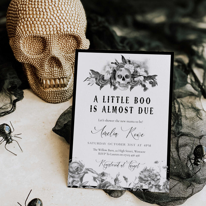 Halloween baby shower invitation with floral skull design and ‘A Little Boo Is Almost Due’ text for spooky celebration.