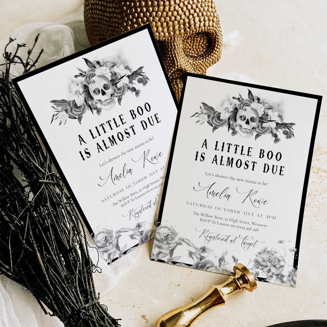 Elegant Halloween baby shower invitation with floral skull illustration and decorative border.