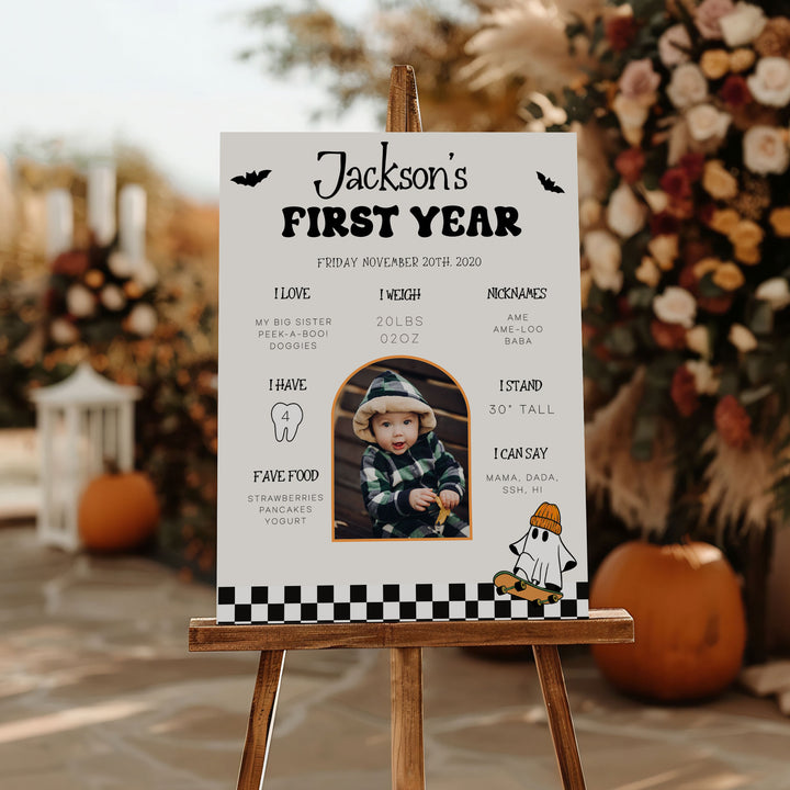 Custom one-year-old birthday poster featuring black-and-white checker border, fall floral decor, and cute bat accents.