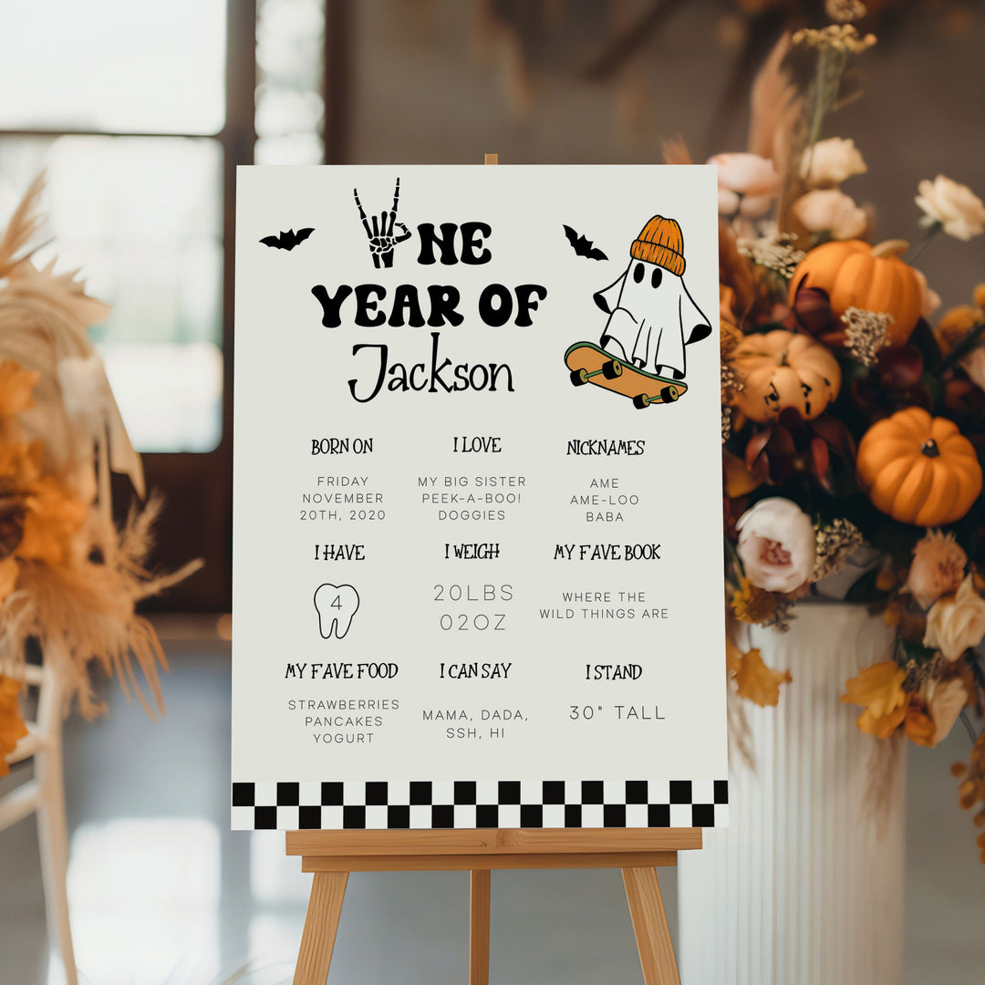 Halloween-themed first birthday milestone poster with a cute ghost in a beanie, ideal for celebrating baby’s spooky one-year milestone in October.