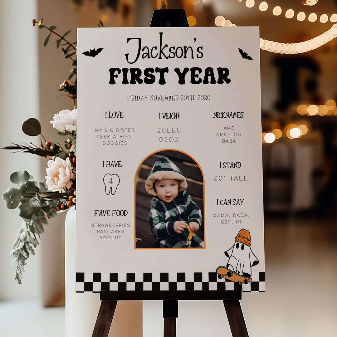 Editable one-year milestone chart with Halloween graphics and pumpkin decor, perfect for fall baby birthday photo shoots.