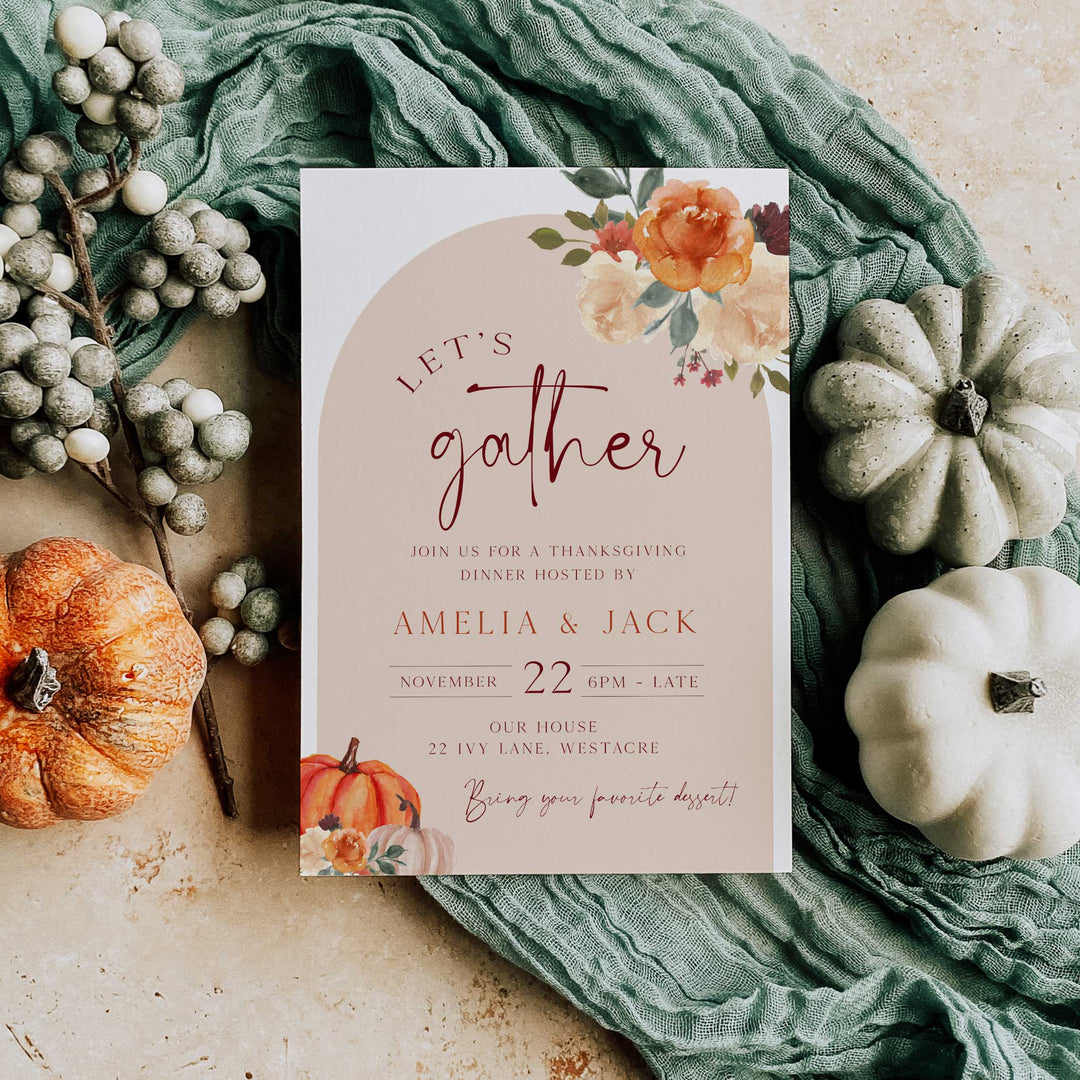 Thanksgiving dinner invitation card held in hand, featuring floral and pumpkin illustrations, perfect for hosting a fall gathering.