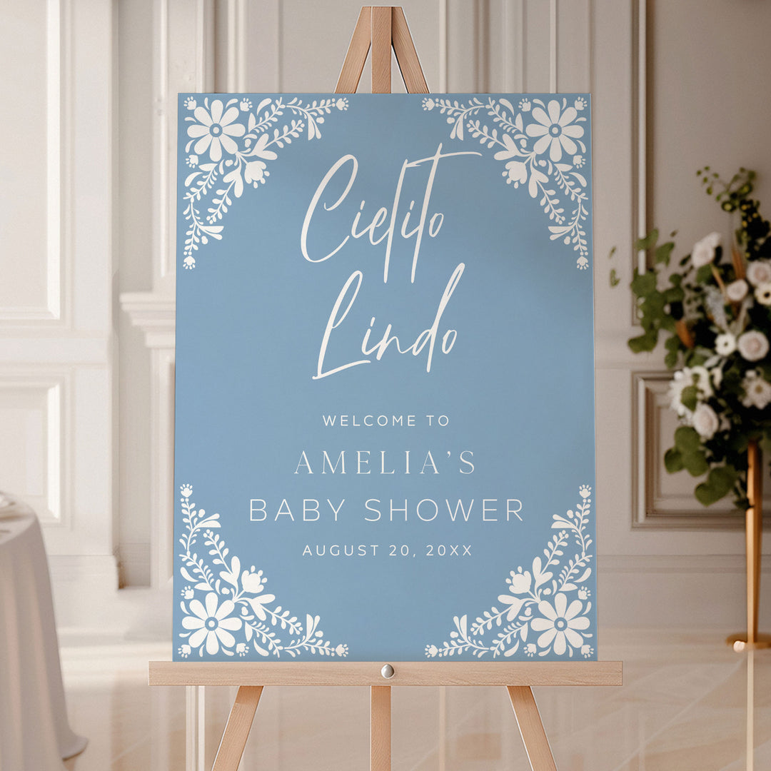 Personalized Cielito Lindo welcome sign in soft blue with floral corners, welcoming guests to Amelia’s baby shower.