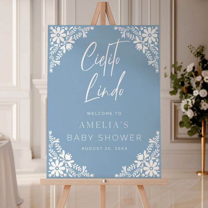 Personalized Cielito Lindo welcome sign in soft blue with floral corners, welcoming guests to Amelia’s baby shower.