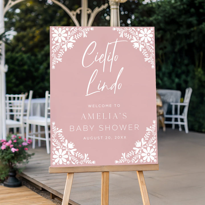 Fiesta-themed pink welcome sign for Amelia’s baby shower, displayed on a wooden easel in an outdoor party setting.